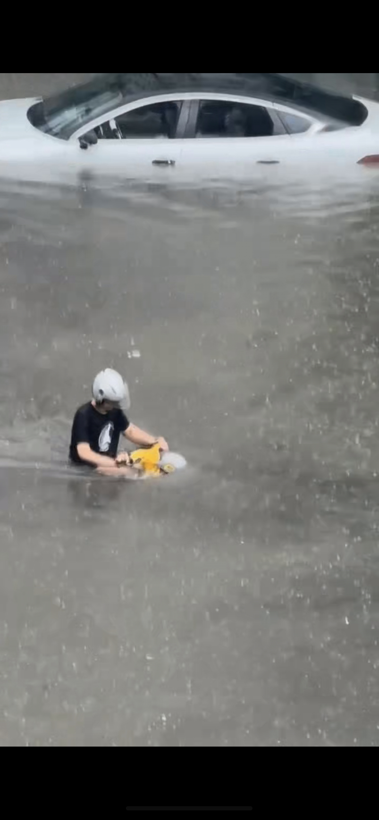 你说他注重安全吧，他还涉水骑电动车，你说他不注重安全吧，他还戴自己的头盔